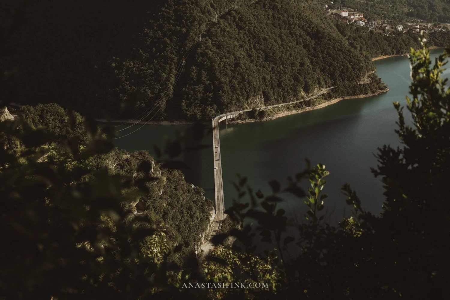 Bridge across Piva Lake seen from above with Pluzine town on the far shore