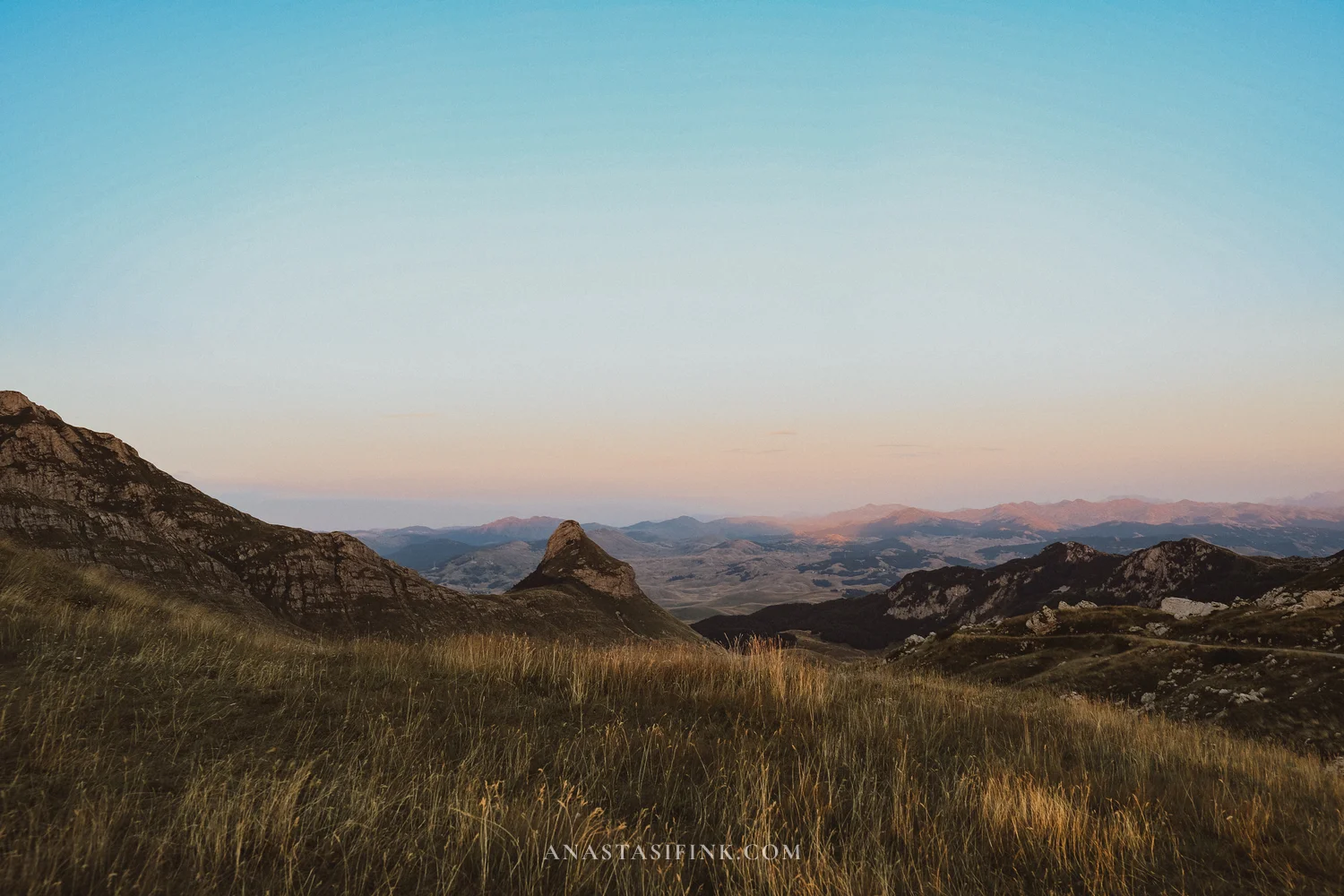 Pink dusk sky over the peaks and grassland at Sedlo Pass, Durmitor, Montenegro