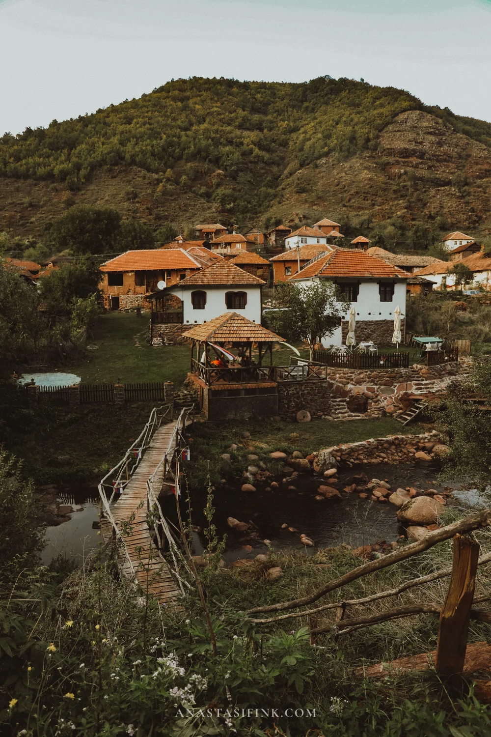 Topli Do village in Stara Planina, Serbia - white houses, wooden bridge over the river and mountain slopes