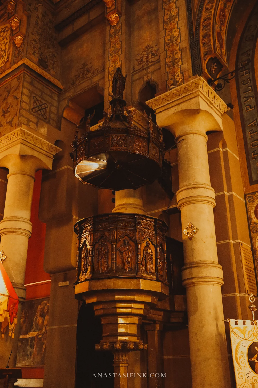 Carved wooden pulpit between stone columns in the Sagrado Corazón basilica, Gijón