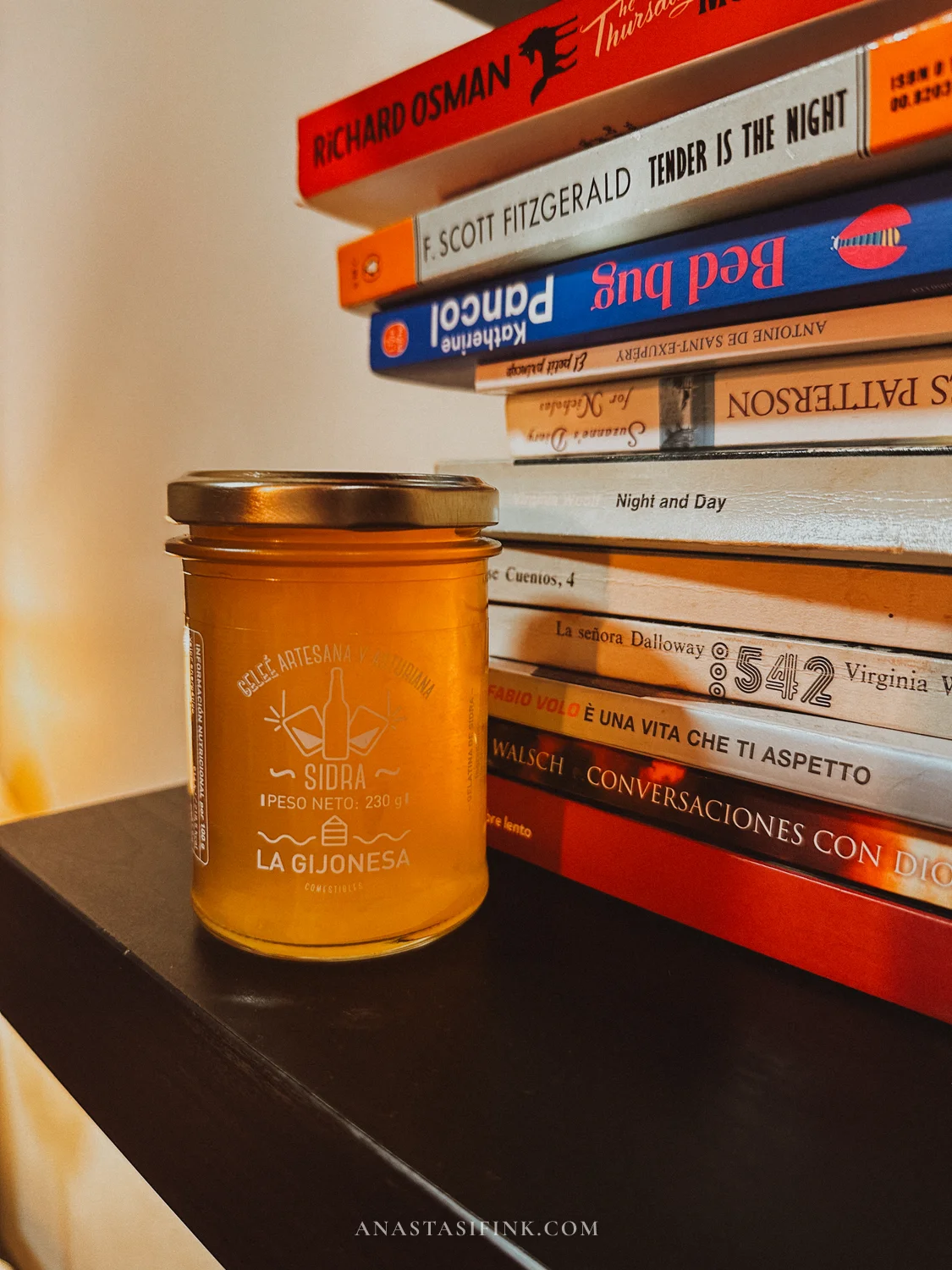 Jar of La Gijonesa artisan cider jelly on a shelf next to a stack of books