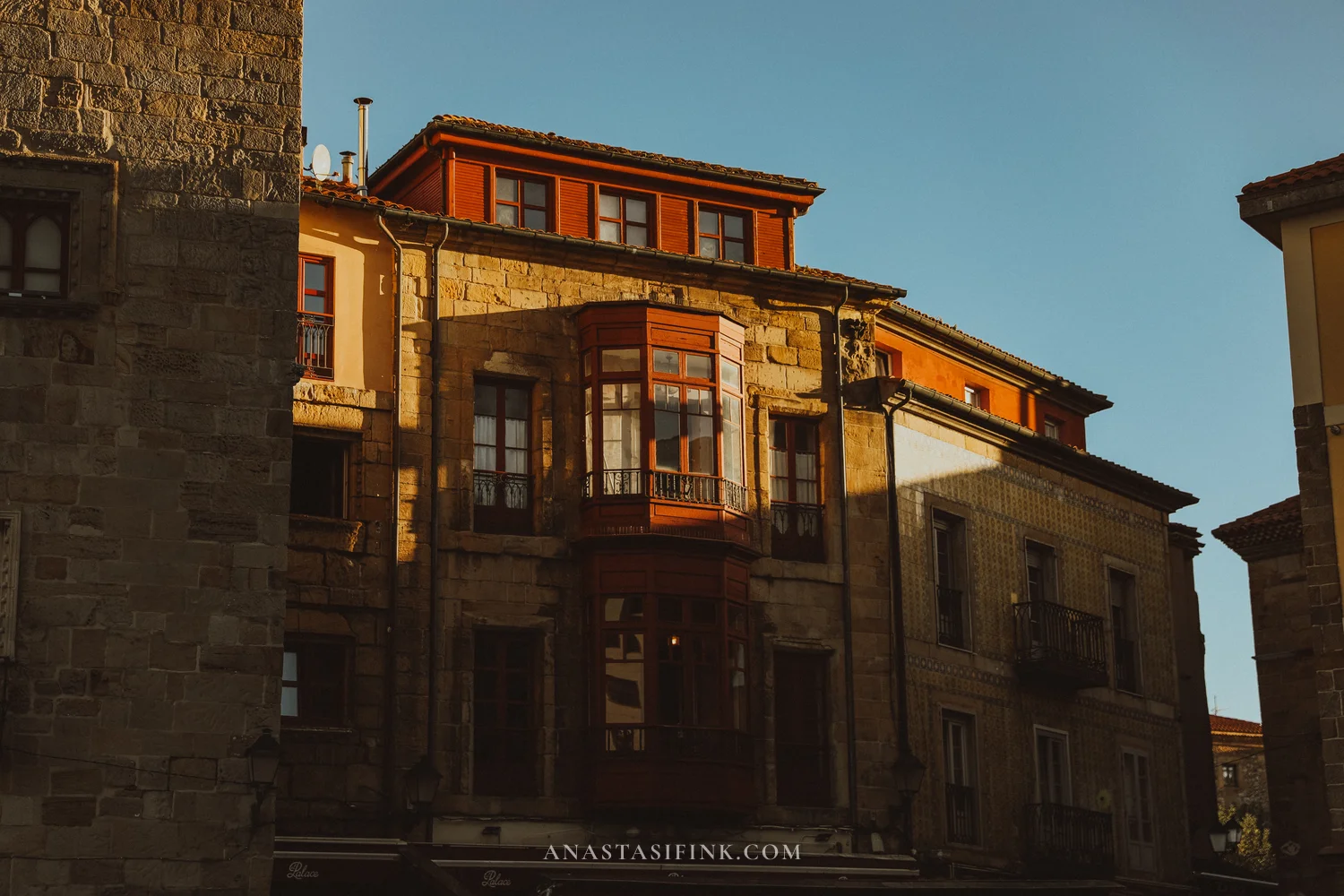 Stone house with a red wooden glass gallery in Cimavilla, Gijón