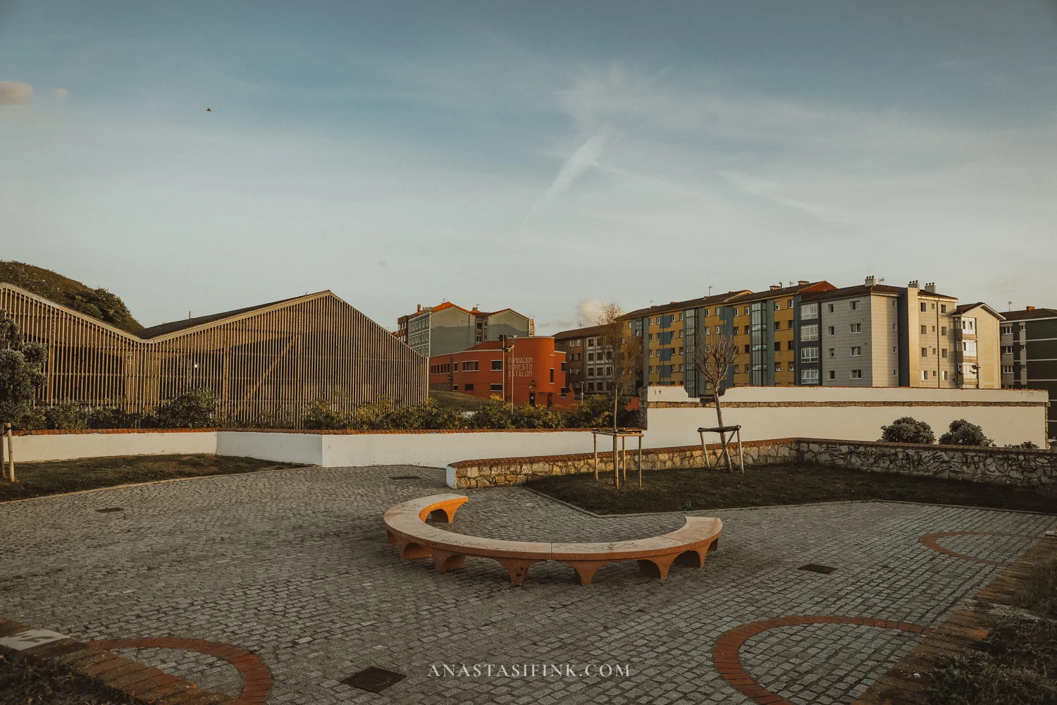 Small square with a curved bench on the edge of Cimavilla in Gijón