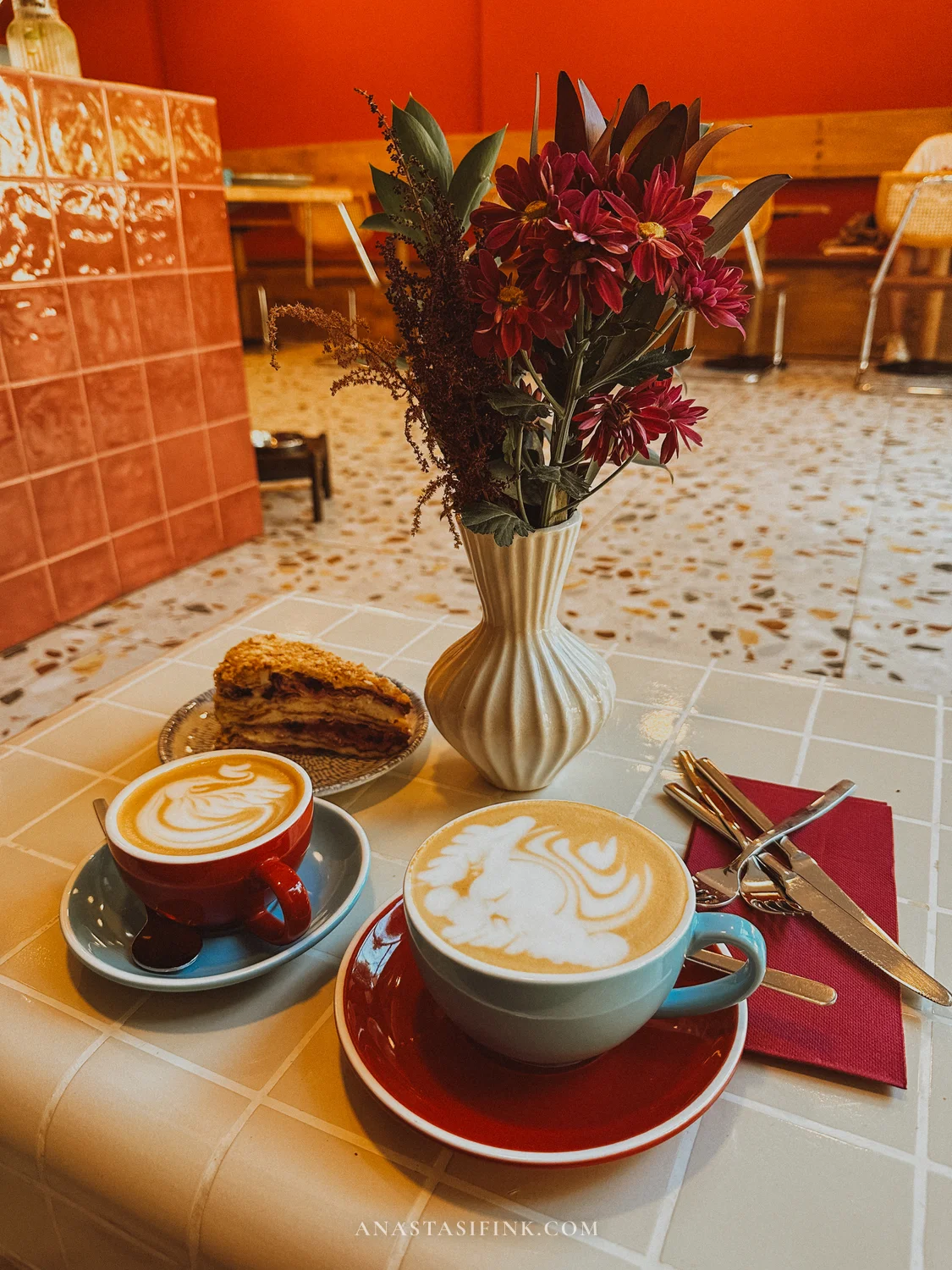 Two cappuccinos and a slice of layered cake at NUBO café in Gijón