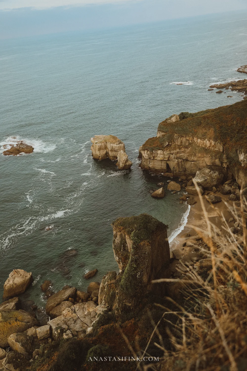 Rocky cove and sea stacks seen from the hidden viewpoint above Playa Centollera, Gijón