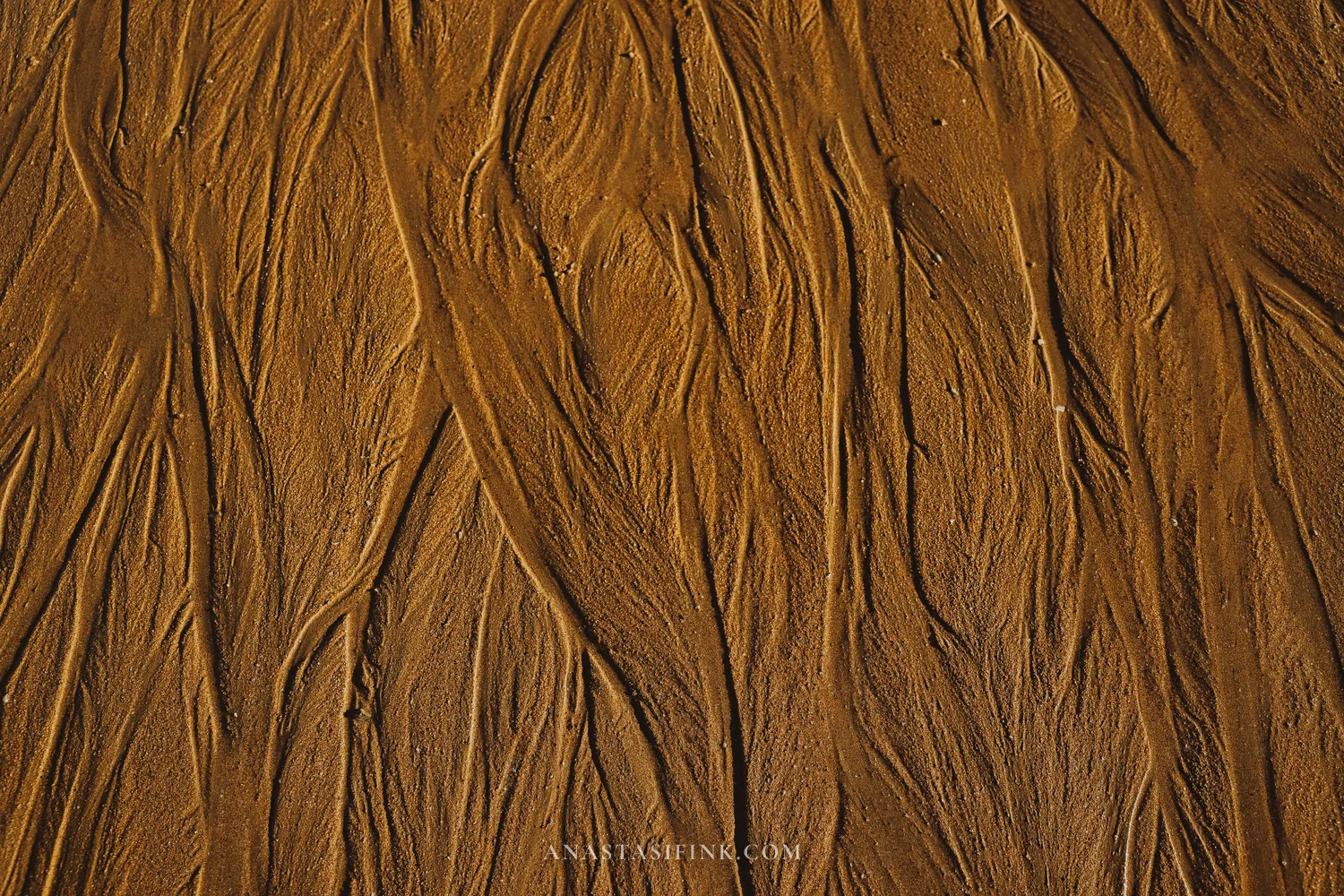 Patterns left by the retreating tide on the sand of San Lorenzo beach, Gijón